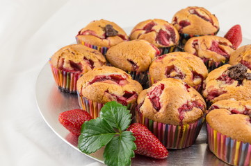 Strawberry muffins on a plate with fresh strawberries