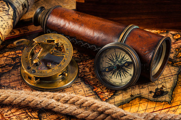 Old vintage compass and navigation instruments on ancient map