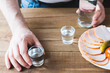 Shot glasses of vodka on a wooden table