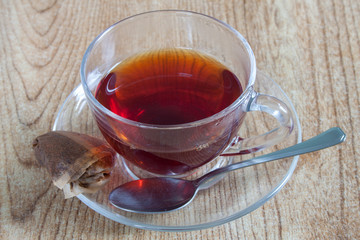 A fresh cup of tea, with a spoon and the used teabag.