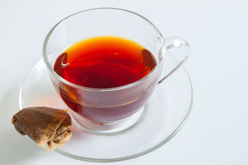 A cup of tea with a used teabag on a white background