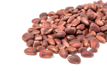 unpeeled pine nuts on a white background