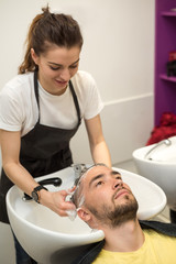 young man washes his head in a hairdressing salon