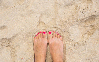 Vacation holidays. Woman feet closeup of girl relaxing on beach in sunny summer day.