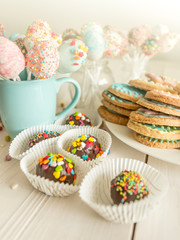 Toned shot of colorful candies, cup and cookies on table at cafe