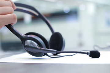 employee's hand taking headset for working concept: callcenter working 