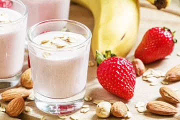 Photo sur Plexiglas Milk-shake Strawberry Banana smoothie with cream, nuts, almonds and oatmeal