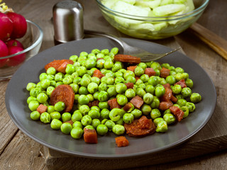 dish cooked with ham and chorizo peas in old wooden