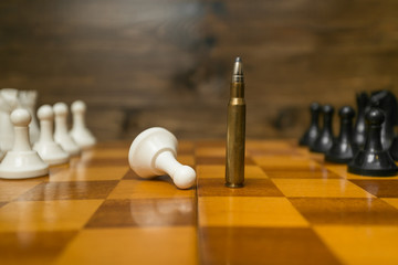 Riffle bullet on chessboard. Concept of power of guns