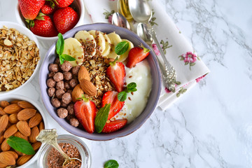 smoothie in a bowl for breakfast with yogurt, strawberries, oatm