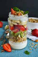 Oatmeal with yogurt, kiwi, banana, strawberries and almonds in a