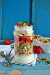 Oatmeal with yogurt, kiwi, banana, strawberries and almonds in a