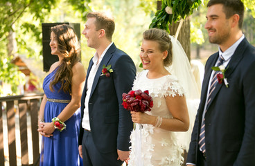 Happy newly married couple and guests at wedding ceremony