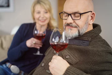 Fotobehang mann riecht mit geschlossenen augen an einem glas rotwein © contrastwerkstatt