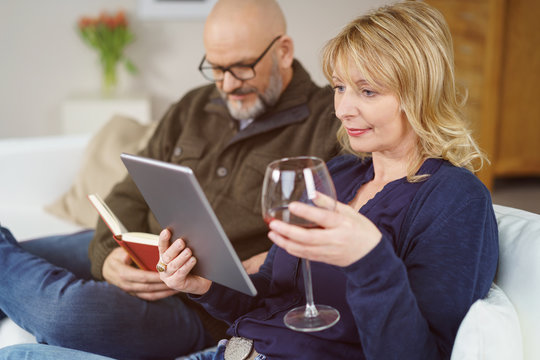 entspanntes paar genie&szlig;t den abend mit lesen und einem glas wein