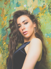 Fototapeta premium beautiful girl in a hotel room on her black dress she poses by the wall
