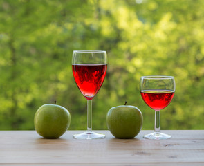  Two wine glasses and  green apples