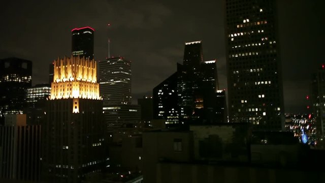 The camera pans from the brilliantly illuminated JP Morgan Chase bank building across the nighttime cityscape of the metropolis of Houston Texas.