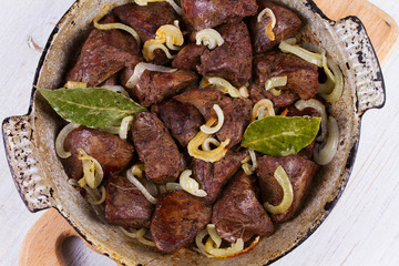 Sauteed liver with onions in pan. View from above