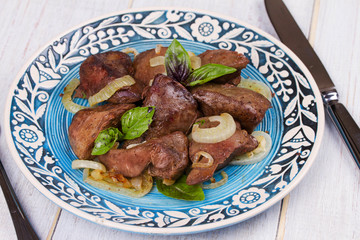 Sauteed liver with onions on blue plate
