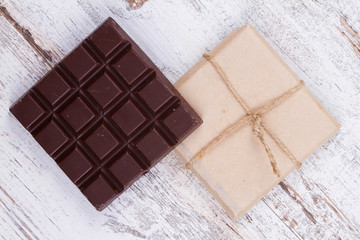 Chocolate bars on white wooden background. View from above