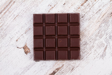Chocolate bars on white wooden background. View from above