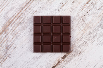 Chocolate bars on white wooden background. View from above