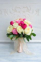 Beauty of colored flowers. Bridal accessories. Close-up bunch of florets. Details for marriage and for married couple. Wedding bouquet with peonies, roses on the white background