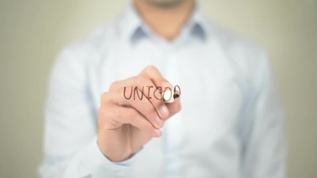 Unicorn , man writing on transparent screen
