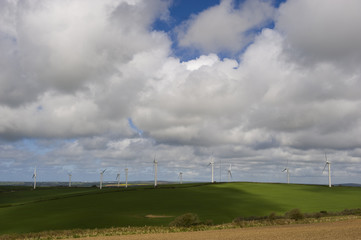 Distant wind turbines against the cloudy Cornish sky.