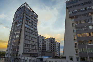 Fototapeta na wymiar City high-rise building at sunset. Facade of a multi-storey residential building at sunset. Building on the sunset sky background. Belgorod city.