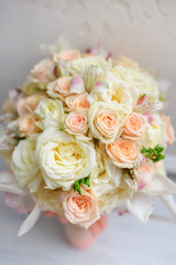 Beauty of colored flowers. Bridal accessories. Close-up bunch of florets. Details for marriage and for married couple. Wedding bouquet with tender orchids, roses on the white background