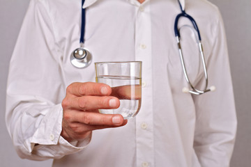 Doctor holding a glass of water close up. Health care and medical concept