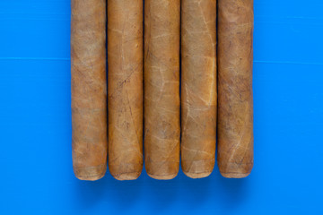 Detail of luxury Cuban cigars on the blue desk