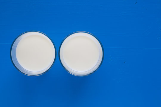 Two glasses of milk on the blue wooden table