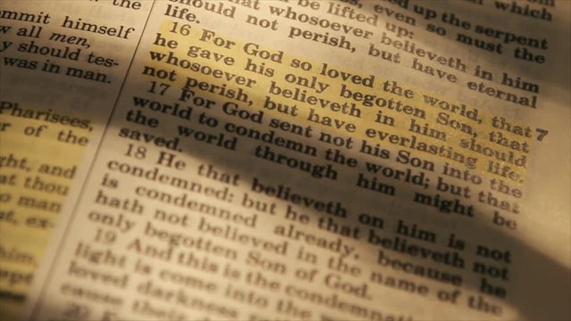 A closeup of  the text of a Bible from chapter 3 verse 16 of the book of John.