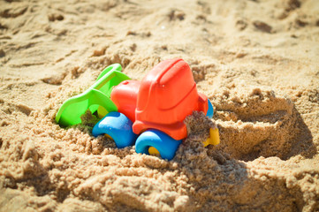 Fototapeta na wymiar Bulldozer toy on the beach sunny day outdoors background