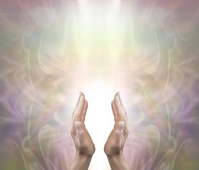 Pranic Healer sending distant healing - Male parallel hands with a white light behind on a soft ethereal misty muted color background and copy space