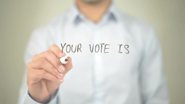 Your Vote is your Voice, man writing on transparent screen