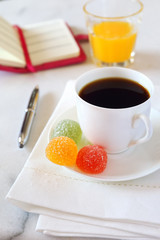 Morning coffee, orange juice, jelly sweets and notebook