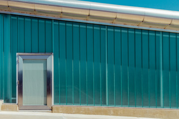 Wall sheets of green glass with glass door and steel