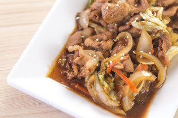 close up kimchi stir fried with pork meat in white plate