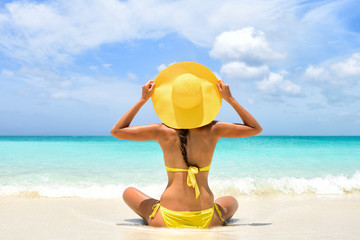 Summer beach vacation carefree happy woman relaxing enjoying sun holiday in tropical destination....