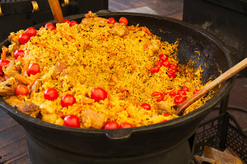 Rice with tomatoes and meat in a big bowl, pilaf. Traditional Middle Eastern dish. Street food