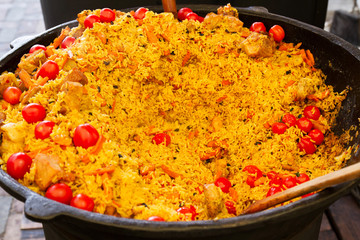 Rice with tomatoes and meat in a big bowl, pilaf. Traditional Middle Eastern dish. Street food