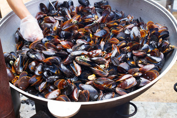 Mussels in big cauldron. Street food