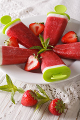 Strawberry sorbet with yogurt and mint on a stick closeup. vertical
