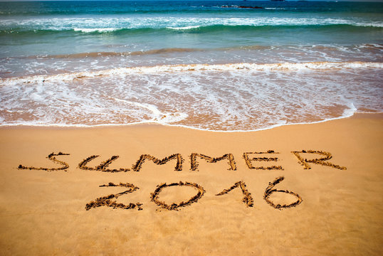 Inscription on wet sand Summer 2016. Concept photo of summer vacation.