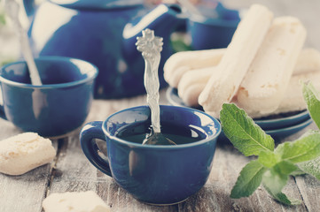 Tea being poured into cup. Toned photo