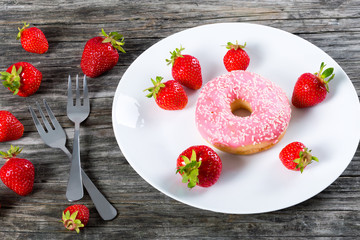 Donut with Strawberry Icing on white dish. close-up
